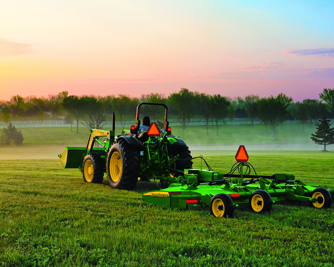 John Deere Tractor with attachment is mowing lawns